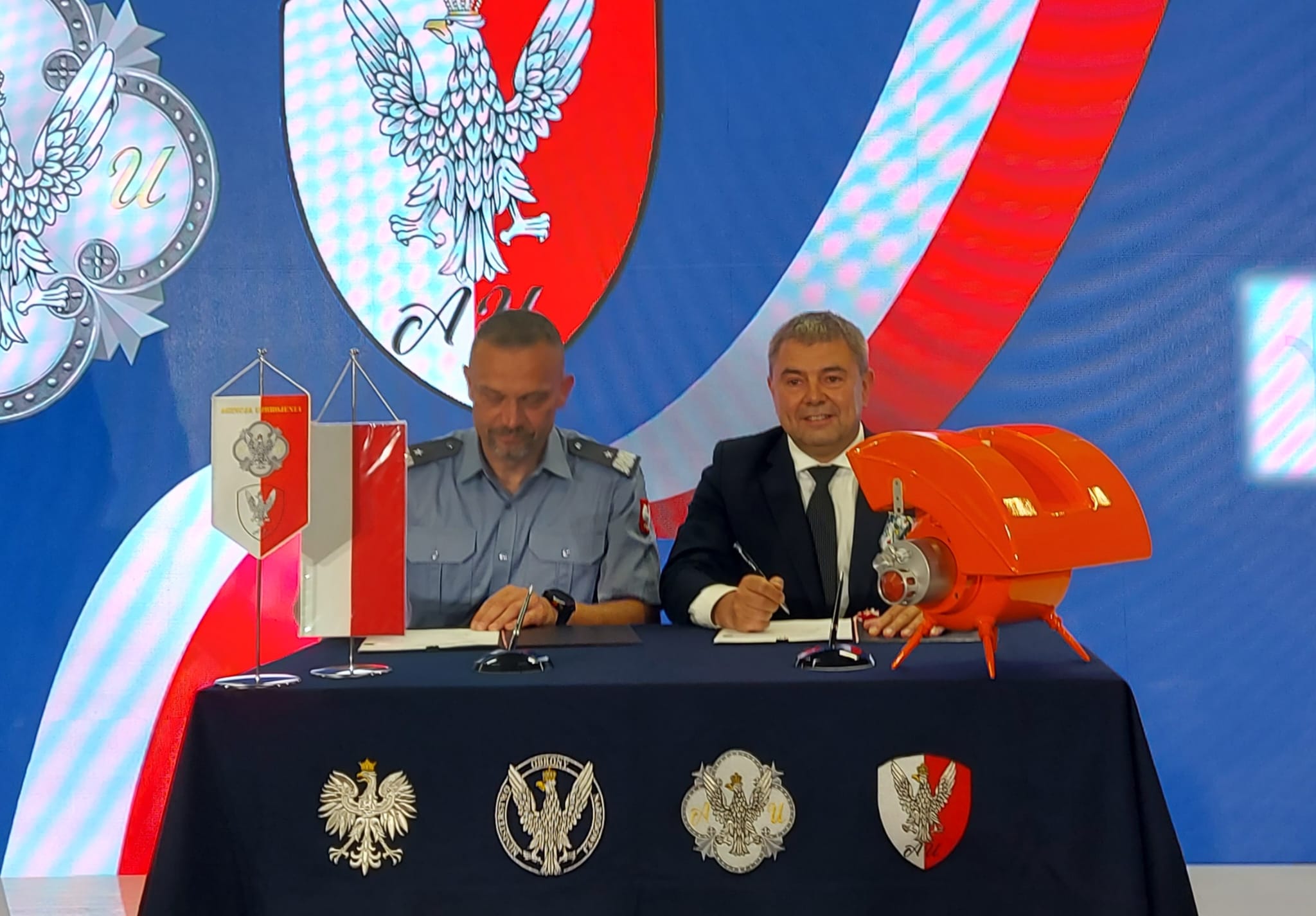 Podpisanie umowy — przedstawiciel Agencji Uzbrojenia i OBR CTM przy stole z ładunkiem „Toczek”