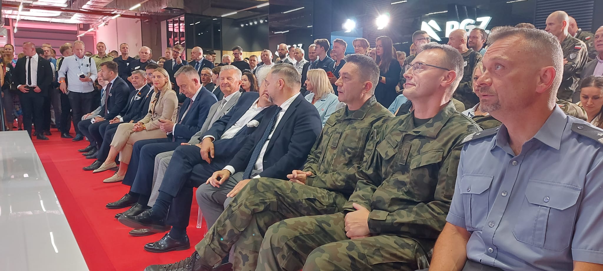 Publiczność podczas uroczystości podpisania umów na nowoczesny sprzęt dla Wojska Polskiego na MSPO — w tle logo PGZ